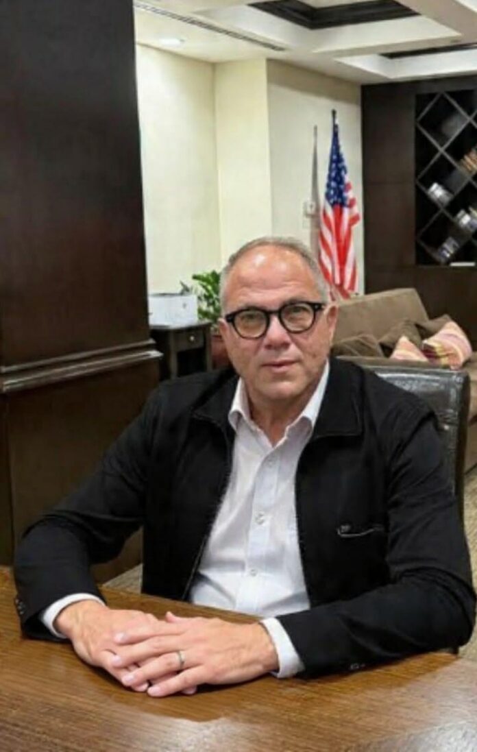Ritratto di Raffaele De Luca in abito e cravatta, ambiente interno.