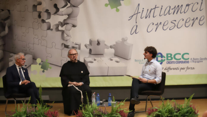 Sergio Gatti, fra Felice Autieri e Gabriele Ruggeri seduti su un palco durante un incontro sul tema dell'economia fraterna