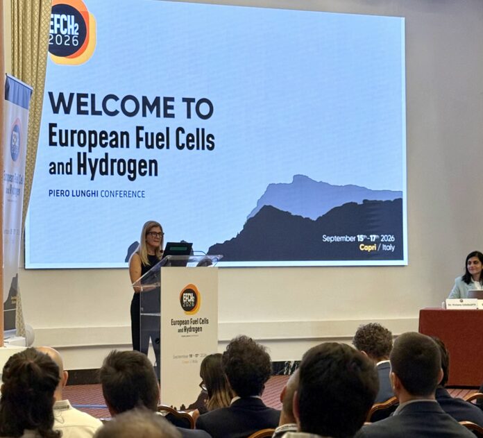 Conferenza sulle tecnologie per l'idrogeno a Capri con presentatrice al podio e pubblico in sala.