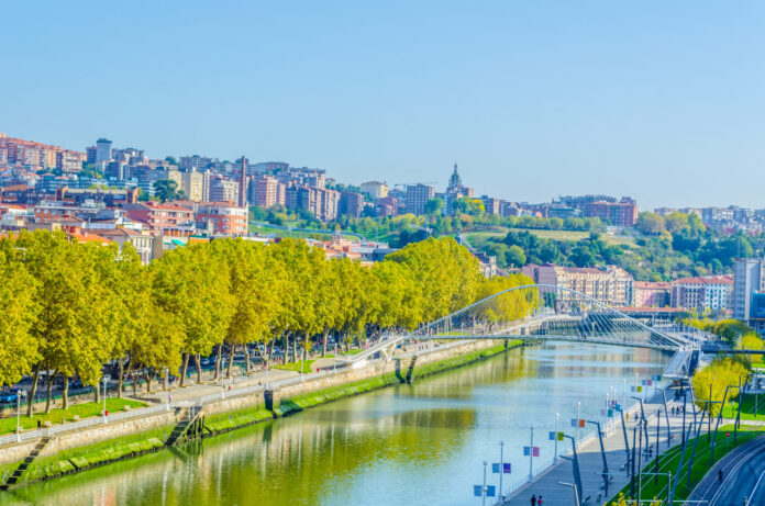 Vista panoramica di Bilbao con il fiume e la città sullo sfondo.