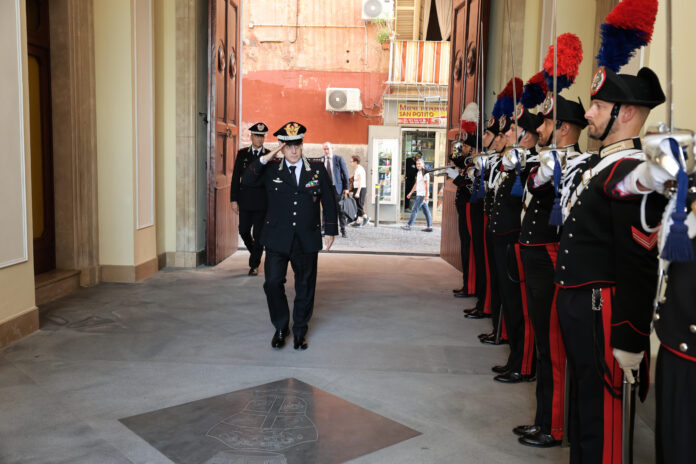 Il Generale di Corpo d’Armata Rosario Castello cammina in un cortile con una schiera di carabinieri in uniforme in attesa.