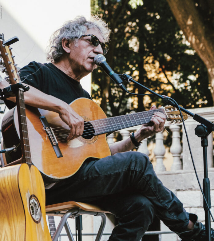 Eugenio Bennato con chitarra durante un concerto all'aperto