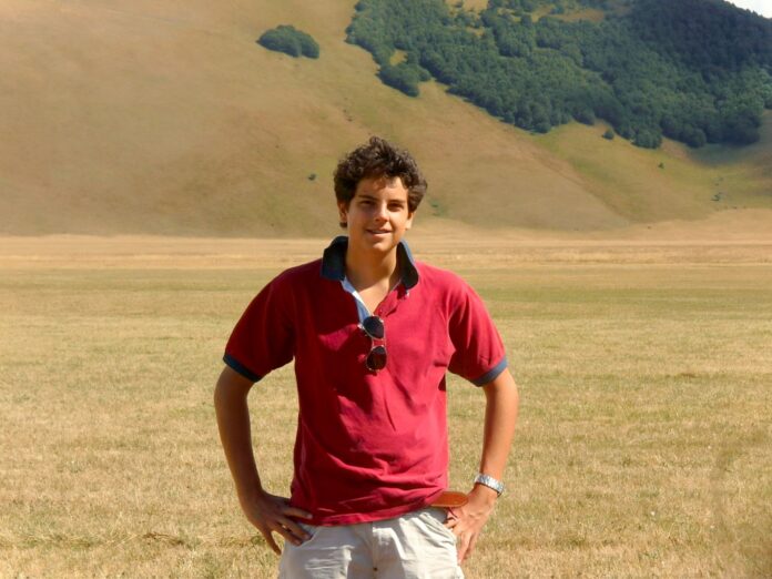 Giovane in campo aperto con colline sullo sfondo, immagine di archivio illustrativa.