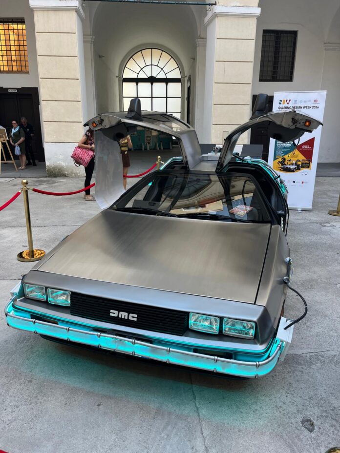 Opera d'arte mostrando una DeLorean DMC-12 in stile collage con vari manifesti e immagini sovrapposte.