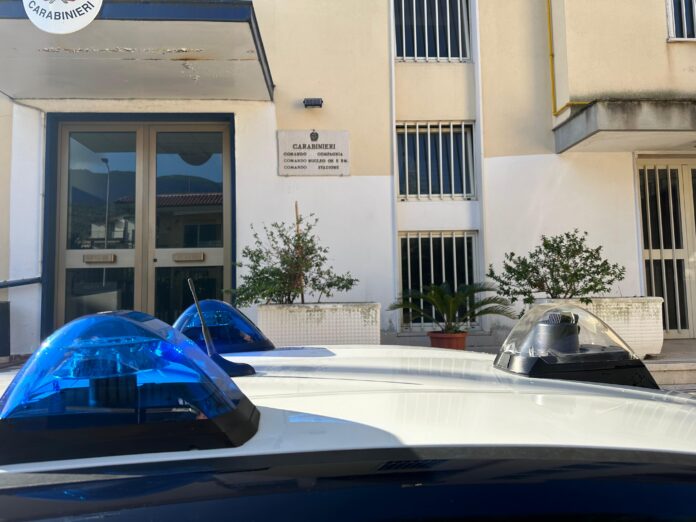 Ingresso di un edificio del Comando Provinciale dei Carabinieri con il tetto di un'auto dei Carabinieri parcheggiata in primo piano.