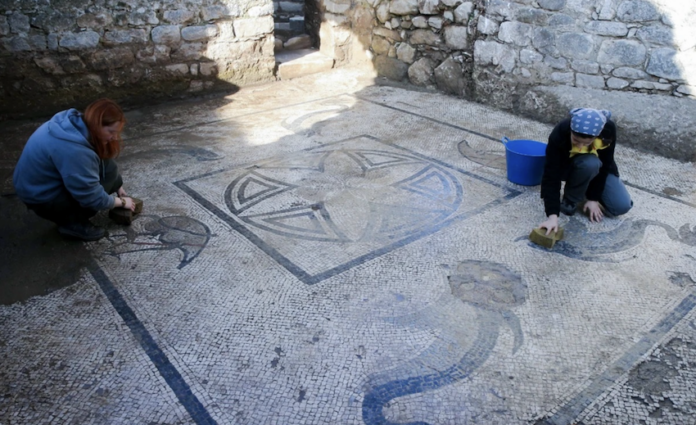 Subacquei esplorano un antico porto sommerso tra rovine sommerse e pesci.