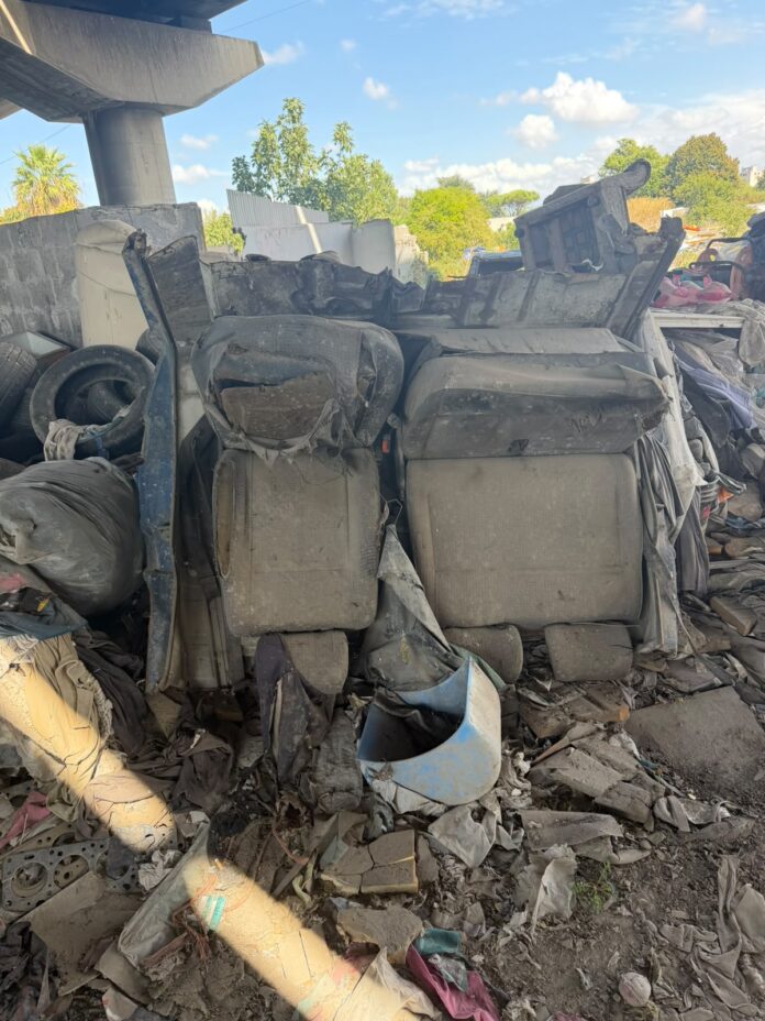 Due persone in un sopralluogo in un'area con rifiuti e vegetazione al campo rom di Cupa Perillo, Scampia