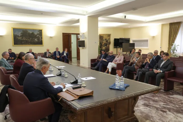 Persone sedute attorno a un tavolo in una sala riunioni.