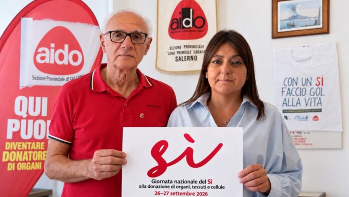 Il presidente provinciale dell'Aido Salerno e la delegata mostrano un cartello con scritto 'Sì' in occasione della campagna sulla donazione di organi.