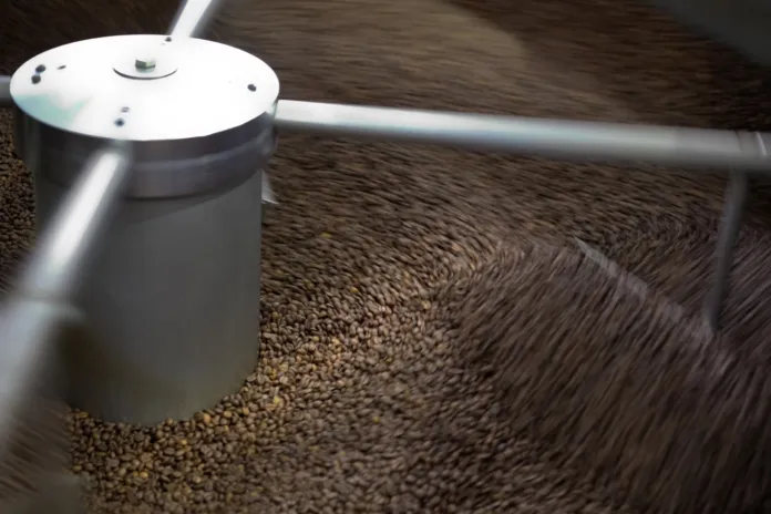 Chicchi di caffè attorno a un macchinario.