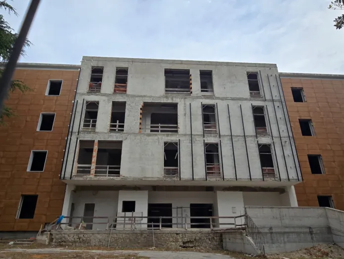 Immagine di un edificio in costruzione o ristrutturazione in un ospedale, con strutture in fase di completamento.