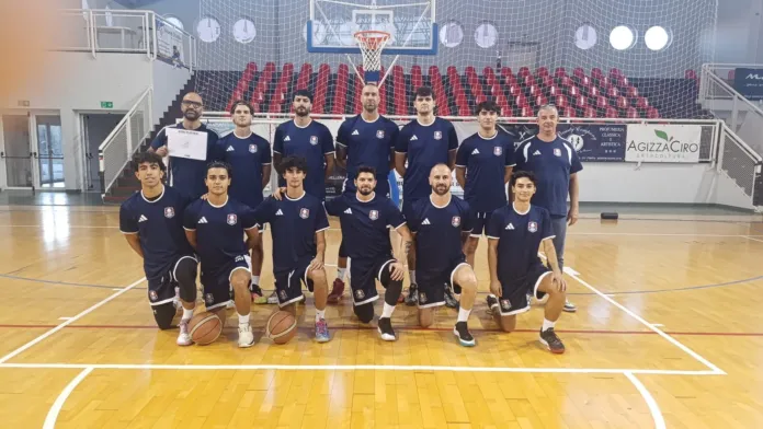 Gruppo di giocatori in divisa scura posa sul parquet di un campo da basket.