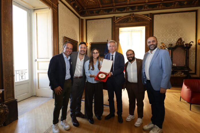 Gruppo di persone in un ufficio formale che mostrano un riconoscimento, immagine illustrativa dell'incontro tra il sindaco Manfredi e The Jackal.