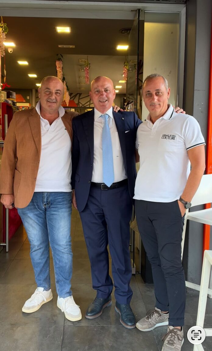 Il consigliere comunale Michele Abenante con due uomini davanti a un ingresso.