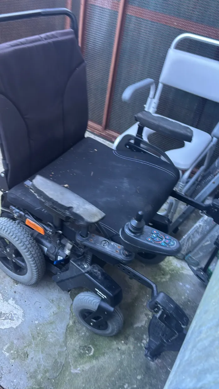 Sedia a rotelle elettrica nera con joystick e ruote motorizzate.