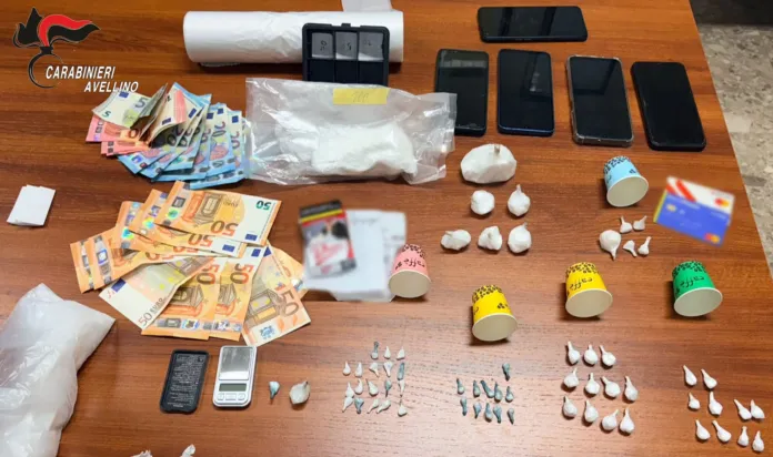 Materiale sequestrato durante un'operazione antidroga con cocaina, crack, denaro e telefoni su un tavolo.