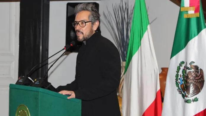 Ambasciatore del Messico in Italia alla tribuna con bandiere italiana e messicana sullo sfondo
