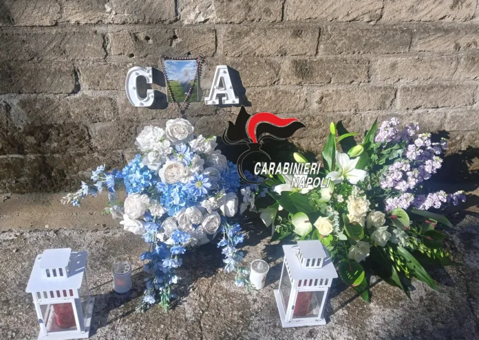 Altarino votivo con candele, fiori e mattonella decorativa, rimosso a Gragnano durante operazioni dei carabinieri.