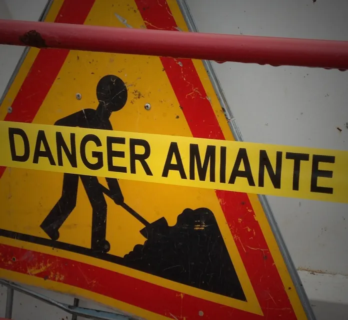Cartello giallo con la scritta «Danger Amiante» e il simbolo di un lavoratore.