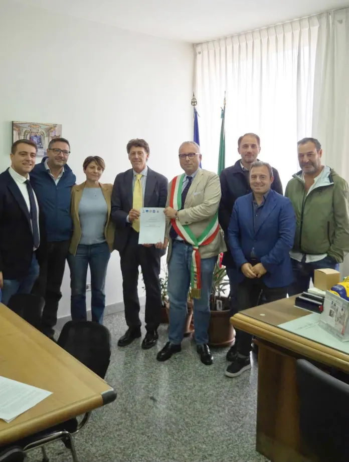 Fotografia di archivio di un gruppo di persone in ufficio durante la firma di un accordo.