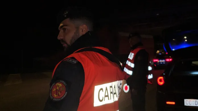 Immagine di controllo stradale notturno dei Carabinieri con personale in divisa e veicoli con lampeggianti
